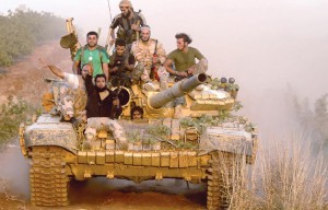 مقاتلون في الجيش الحر
يعتلون دبابة اغتنموها
على جبهة مورك في
ريف حماة