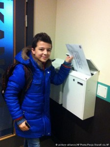 الطفل أحمد واضعًا رسالته في صندوق البريد.