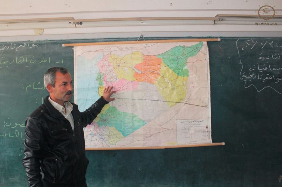مدرس يشرح للتلاميذ خلال حصة جغرافيا في مدرسة بحماة، عنب بلدي.