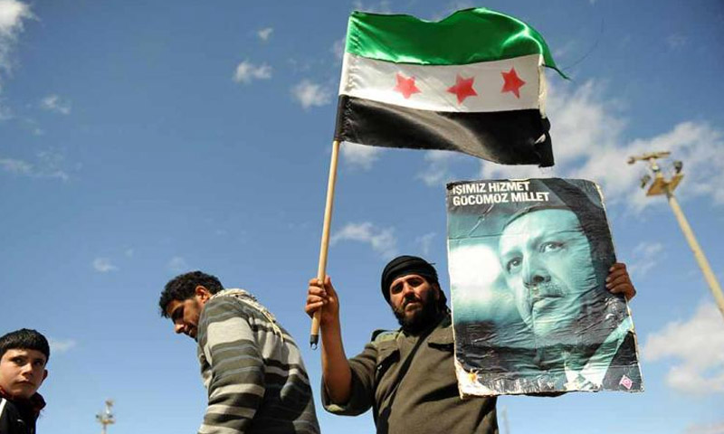 لاجئ سوري يحمل علم الثورة السورية وصورة أردوغان في أنطاكيا آذار 2012 (جيتي)