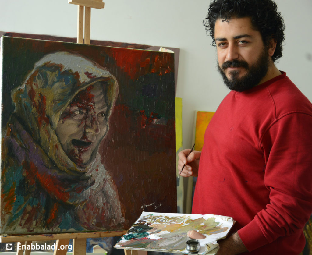 الفنان السوري حسام علوم مع لوحته (عنب بلدي)
