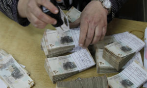 An employee stamps stacks of Syrian pound notes at the Syrian central bank in Damascus April 23, 2013. Picture taken April 23, 2013.        To match SYRIA-CURRENCY/        REUTERS/Khaled al-Hariri (SYRIA - Tags: POLITICS CONFLICT BUSINESS)
