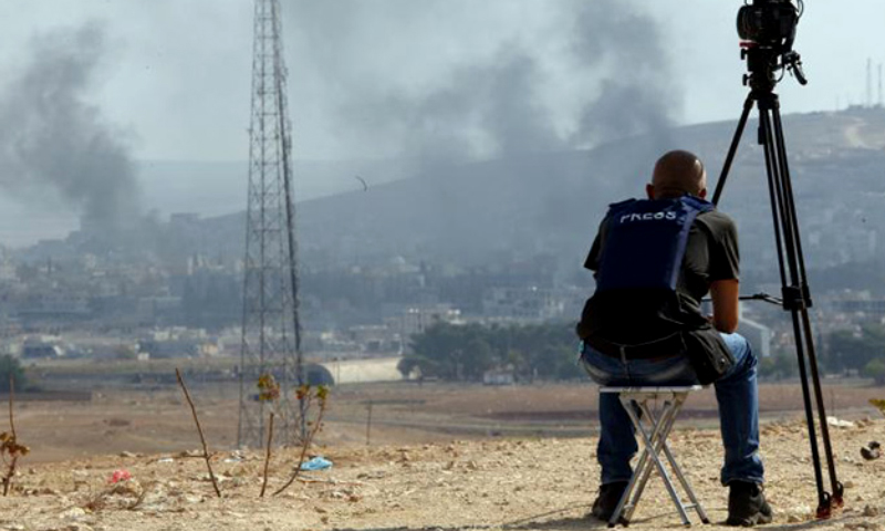 مصور يرصد الدخان المتصاعد من عين العرب (كوباني) - تشرين الأول 2014 (AFP)