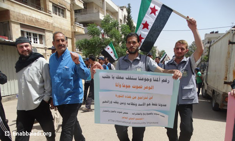وقفة تضامنية في حي الوعر، طالبت بوقف التصعيد في مدينة حلب، الأحد 1 أيار (عنب بلدي).