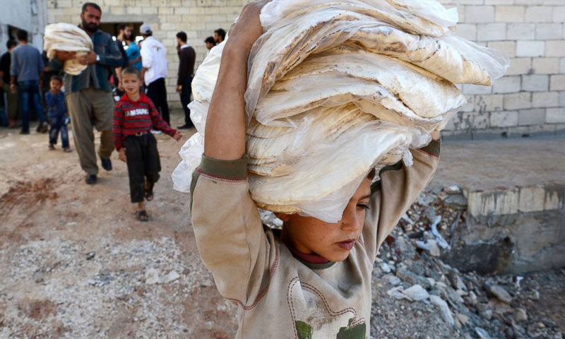 صبي سوري يحمل الخبز في محافظة حلب 2012. (AFP)