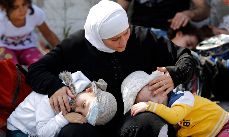 لاجئة سورية تحضن ولديها في تركيا (إنترنت)