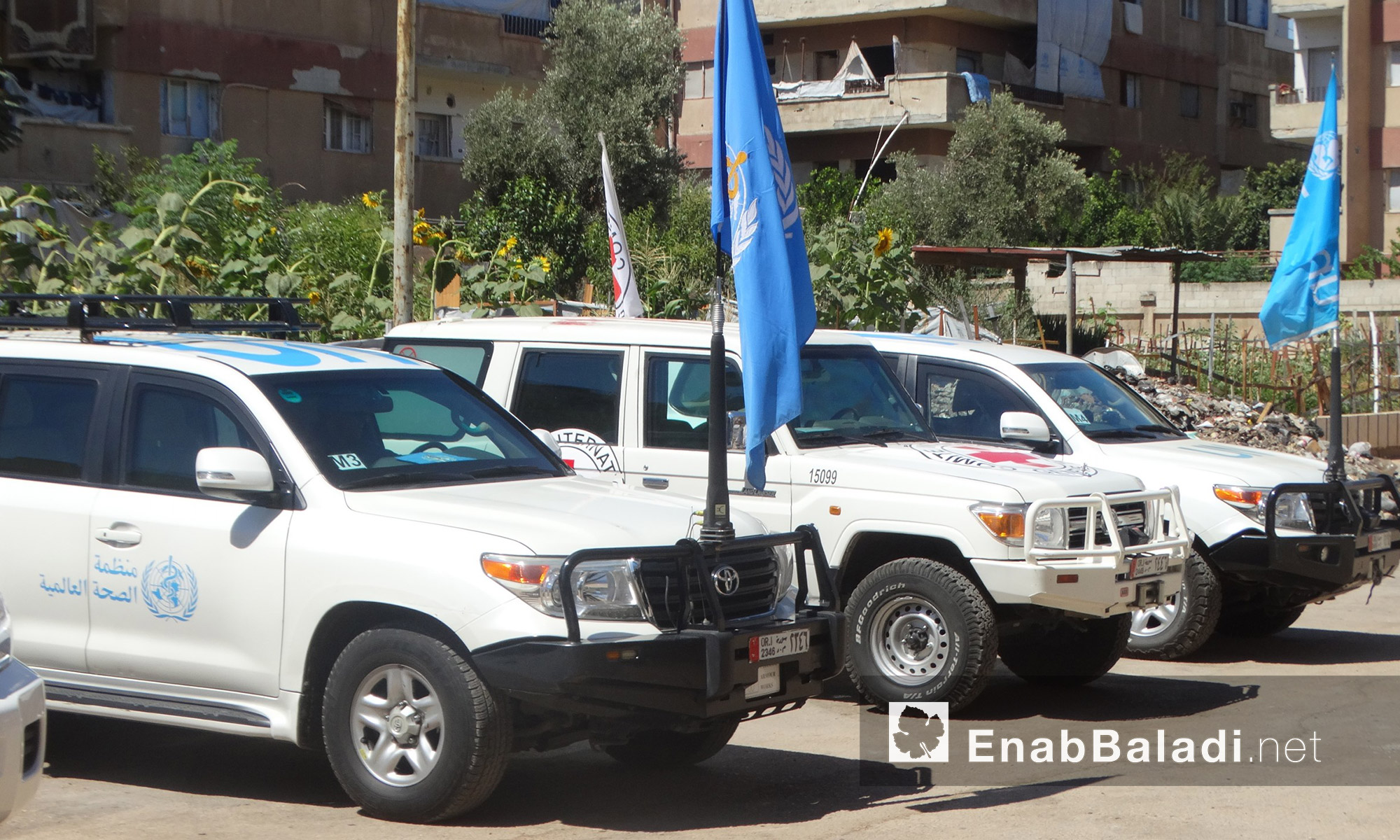 سيارات الوفد المرافق لقافلة  المساعدات داخل حي الوعر في حمص - الخميس 14 تموز (عنب بلدي)