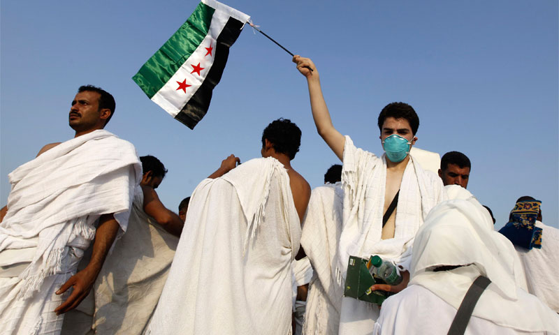 حاج سوري يرفع علم الثور السورية في عرفات