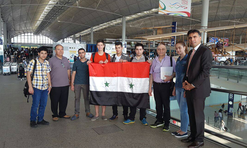 نجل الأسد إلى جانب فريق الأولمبياد السوري للرياضيات في هونغ كونغ (صفحة رئاسة الجمهورية السورية)