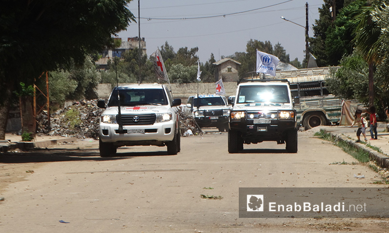 سيارات قافلة المساعدات الغذائية في حي الوعر بحمص - الاثنين 18 تموز (عنب بلدي)