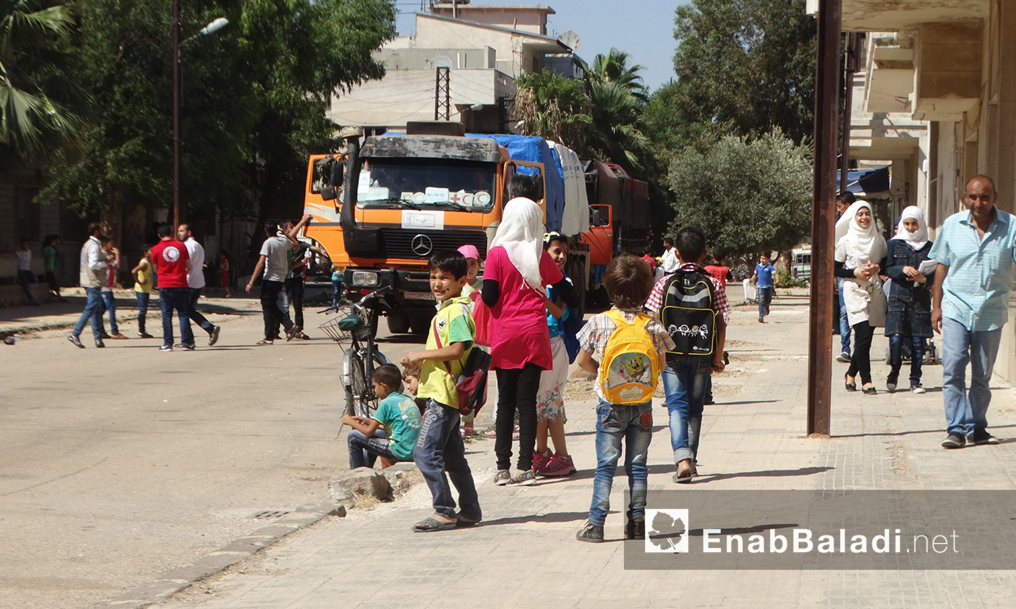 أطفال وأهالي الوعر أثناء دخول قافلة  المساعدات - الخميس 14 تموز (عنب بلدي)