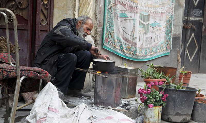 رجل يطبخ باستخدام الحطب في حلب 22 كانون الثاني (روتيرز)