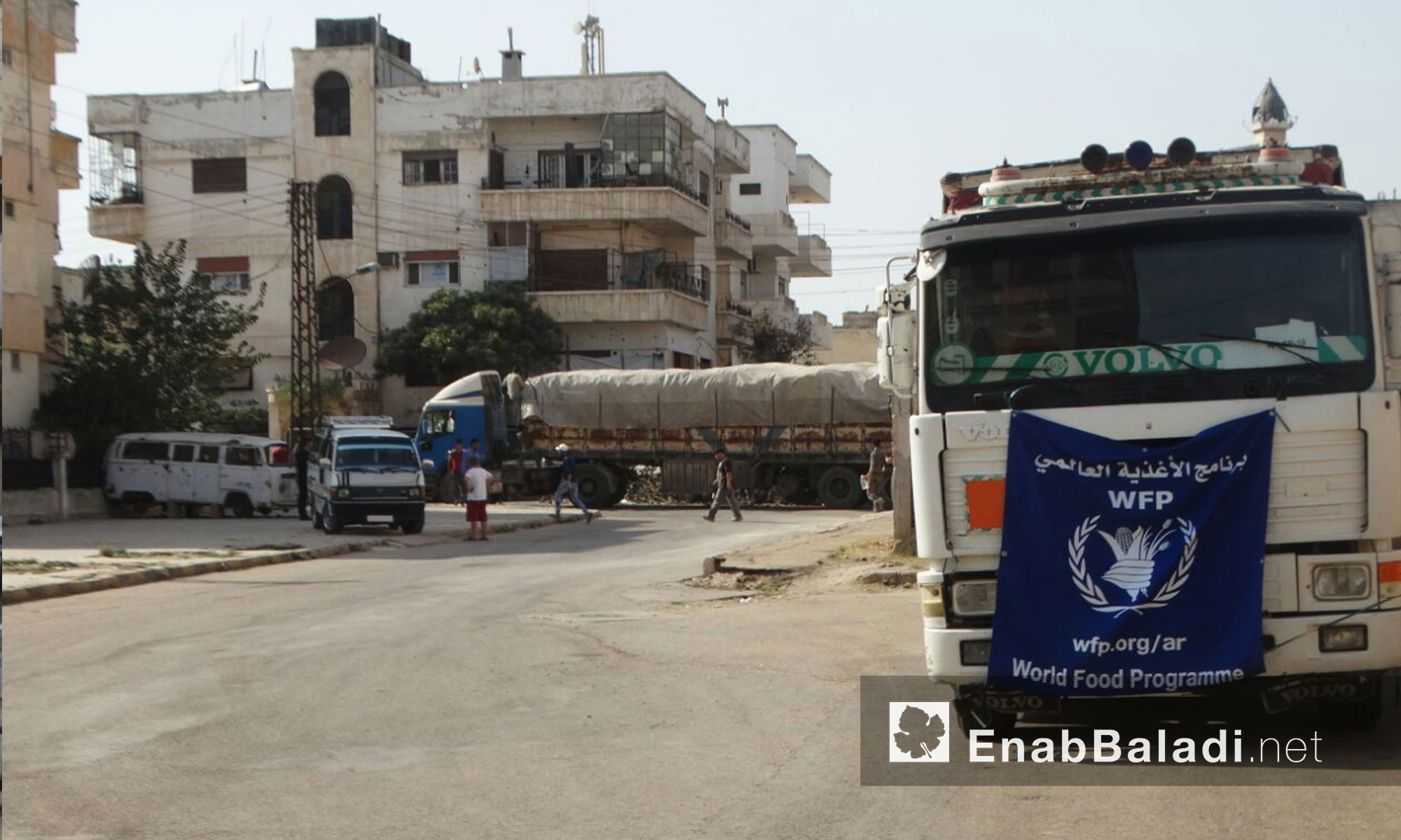 شاحنة تحوي أكياس ضمن  قافلة المساعدات الإنسانية داخل حي الوعر المحاصر - الخميس 25 آب (عنب بلدي)
