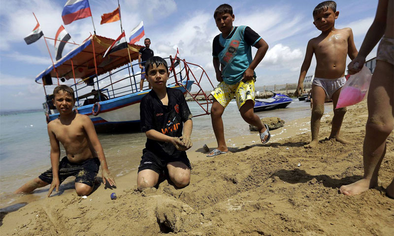أطفال سوريون على أحد شواطئ اللاذقية أيار 2014 (AFP)