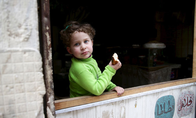 طفلة تتناول الخبز عند محلّ للمأكولات الشعبية في حي القابون في دمشق
آذار 2016
(رويترز)