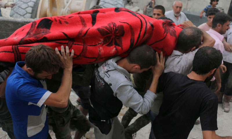 مواطنون يحملون جثمان أحد ضحايا القصف الجوي على حي المرجة في مدينة حلب- الجمعة 23 أيلول (AFP)