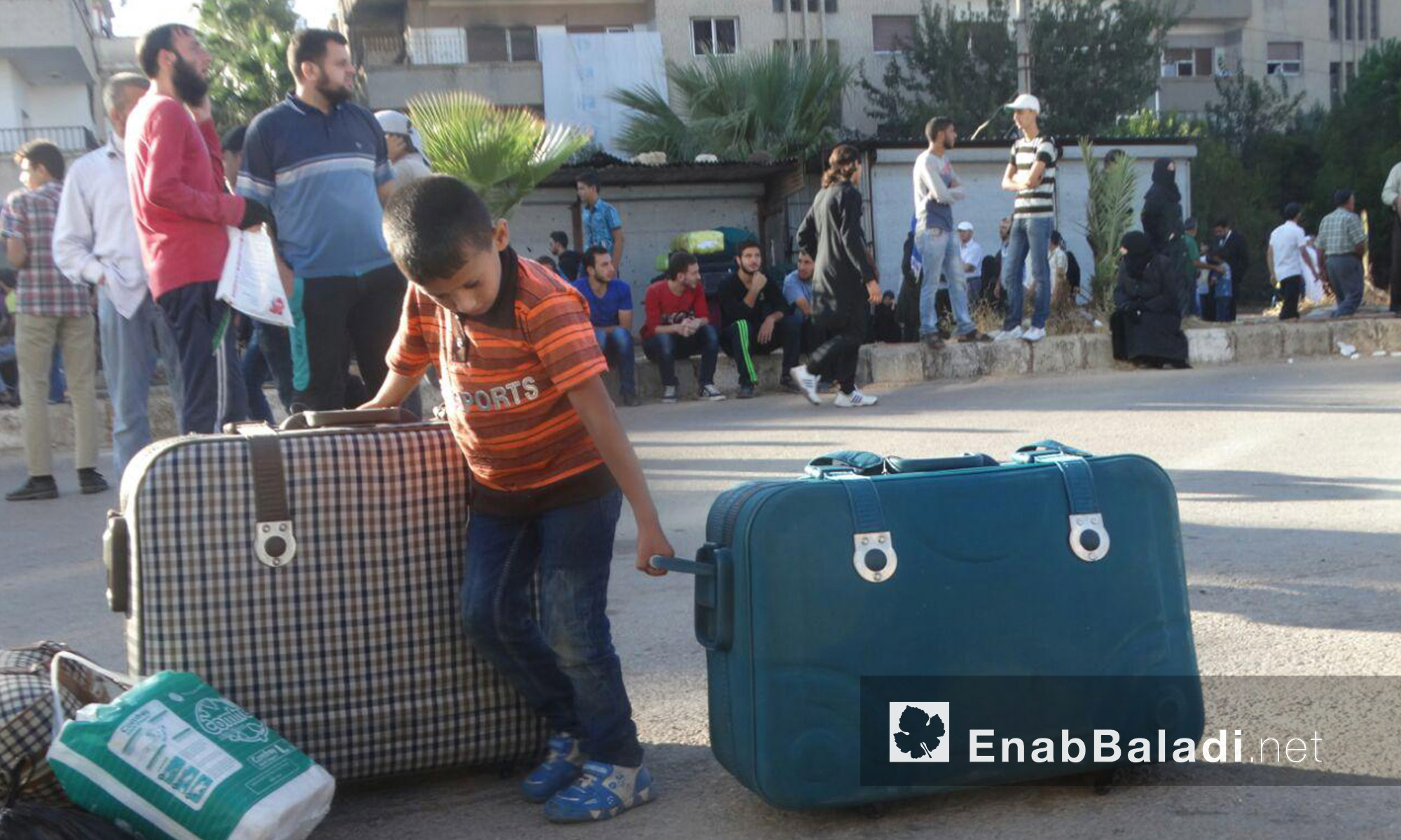 طفل يجهز حقائب عائلته قبل الخروج من الحي إلى ريف إدلب - الاثنين 19 أيلول (عنب بلدي)