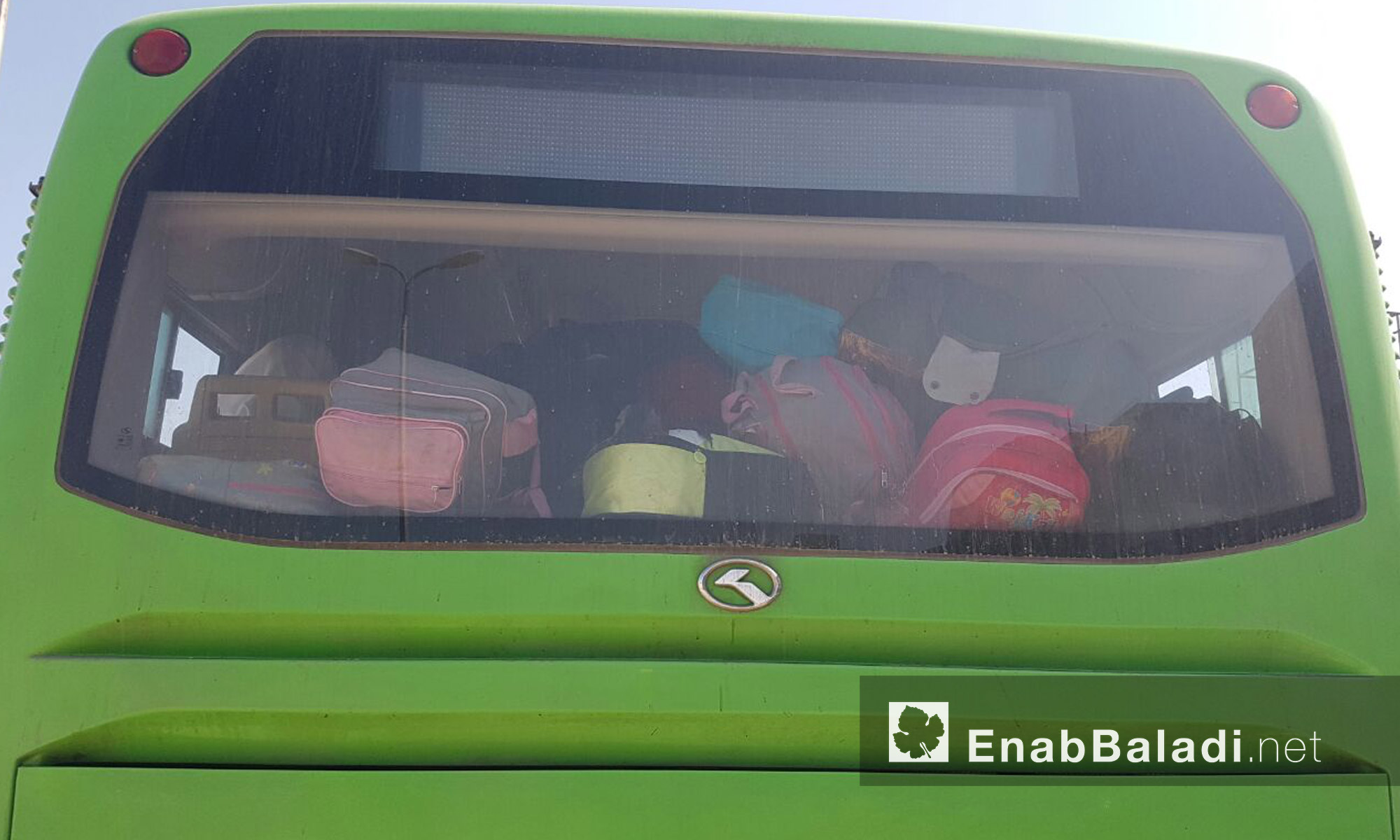 حقائب عائلات الوعر داخل الباص الأخضر قبل خروجهم إلى ريف حمص الشمالي - الخميس 23 أيلول (عنب بلدي)