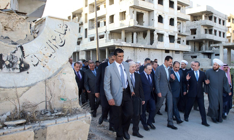 بشار الأسد مع عددٍ من المسؤولين وإلى جانبهم قاعدة تمثال الأسد دون رأسه (فيس بوك)