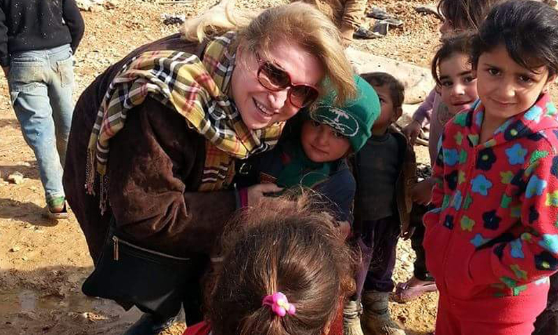 السيدة راوية الأسود، مؤسسة منظمة "سوريات عبر الحدود، مع عددٍ من الأطفال السوريين (فيس بوك)