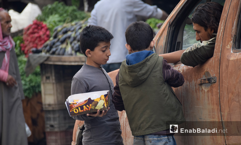 طفلان يبيعان "البسكويت" للمارة في مدينة حلب - تشرين الأول 2016 (عنب بلدي)