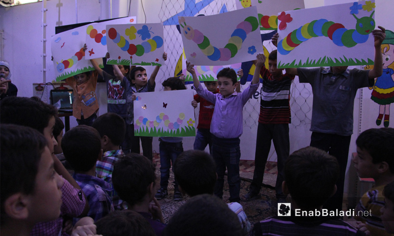 أطفال سوريون يعرضون رسوماتهم في مدينة دوما - تشرين الأول 2016 (عنب بلدي)