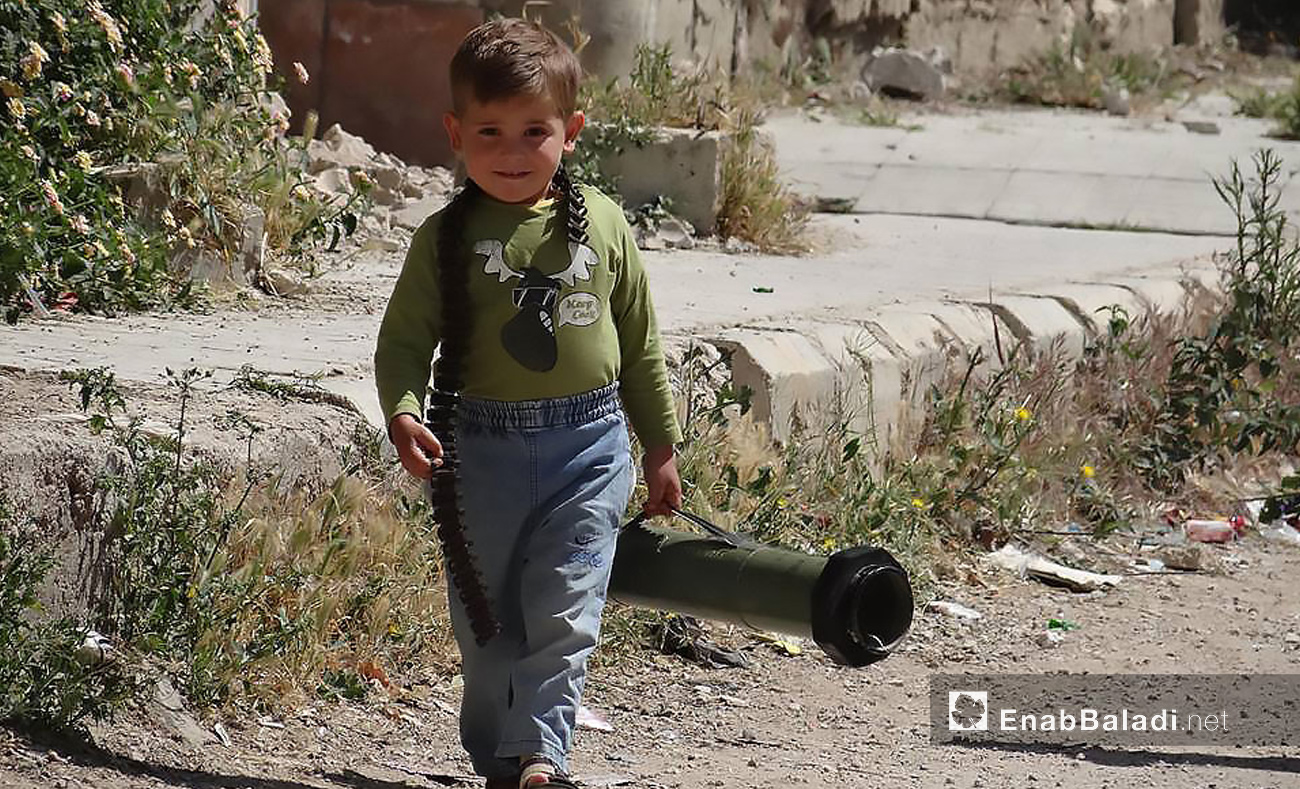 طفل سوري يحمل سلاحًا في مدينة درعا جنوب سوريا - تشرين الأول 2016 (عنب بلدي)