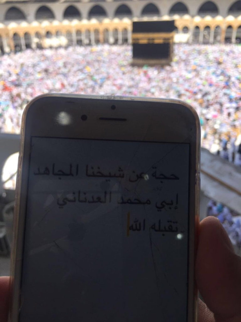 حاج يحمل لافتةً كتب عليها حج عن “أبو محمد العدناني” (تويتر)