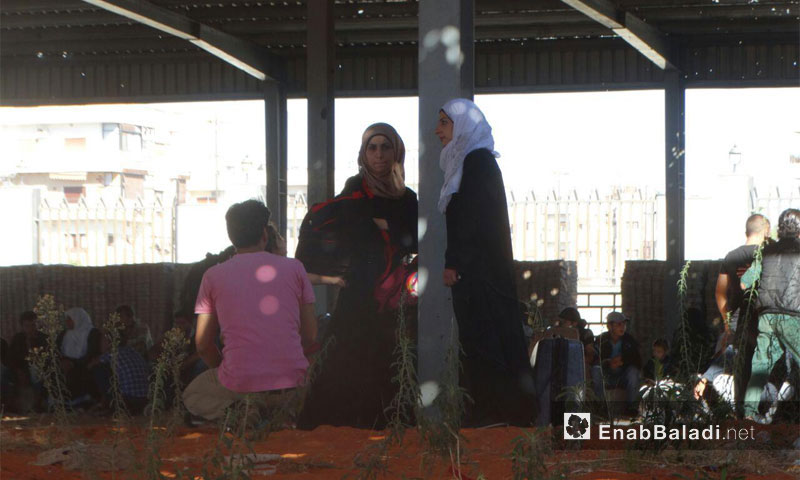نساء حي الوعر ينتظرون الخروج إلى ريف حمص الشمالي - أيلول 2016 (عنب بلدي)