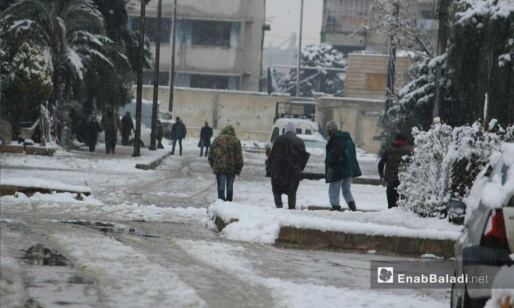حركة الأهالي في حي الوعر أثناء تساقط الثلوج_18 كانون الأول_(عنب بلدي)