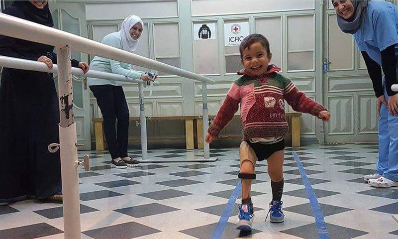 طفل سوري فرح بقدمه الجديده بعد أن فقد السابقة بسبب القصف_(تويتر)