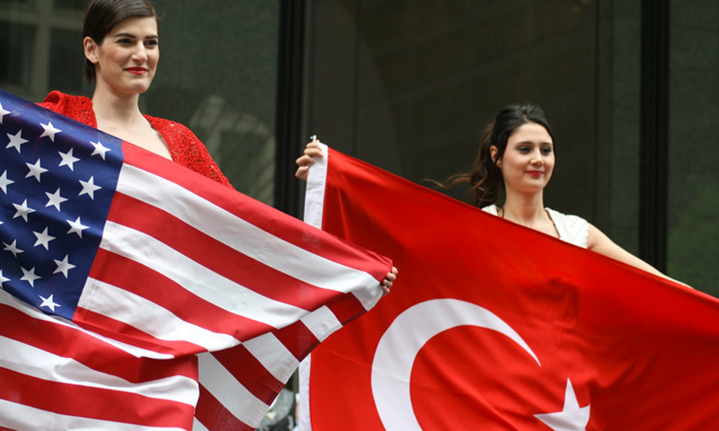 مواطنتان تركيتان ترفعان علمي تركيا والولايات المتحدة (إنترنت)