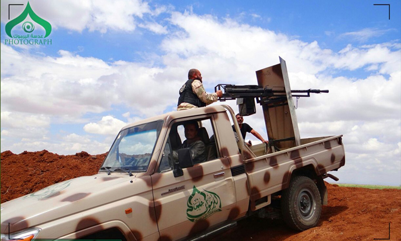 مقاتلون يعتلون سيارة تحمل رشاشًا تابعة لجيش اليرموك في درعا (جيش اليرموك)