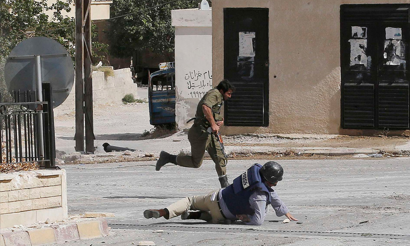 مراسل وكالة "AFP" ملقىً على الأرض إثر رصاصات قناص في معلولا بريف دمشق - 18 أيلول 2013 (عنب بلدي)
