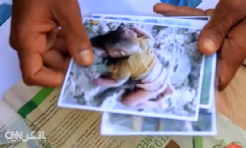 صورة للطفل محمد شيهات يحملها والده (شبكة CNN)