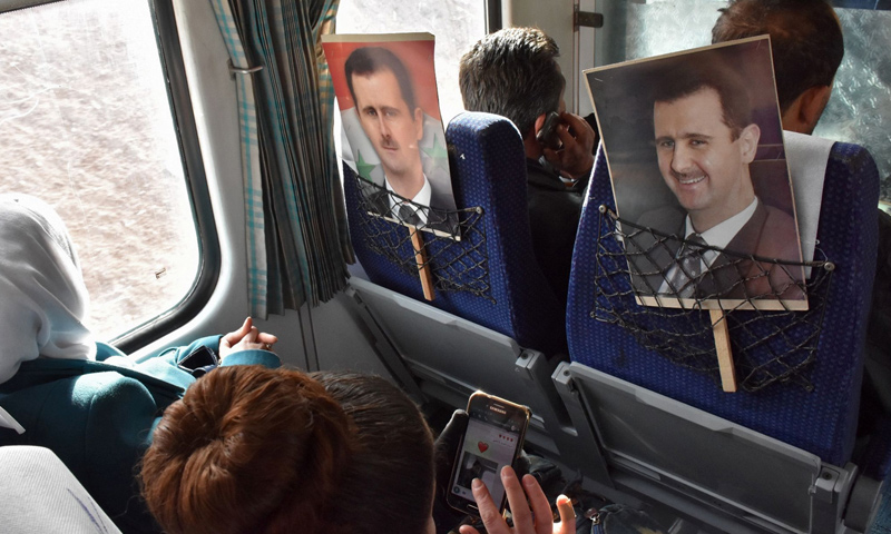 لافتات تحمل صورة بشار الأسد في إحدى الحافلات في سوريا_كانون الأول 2016_(AFP)