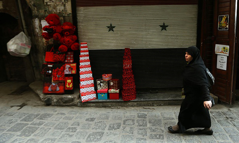 امراة سورية تمشي بجانب متجر في دمشق 10 شباط 2016 (AFP)