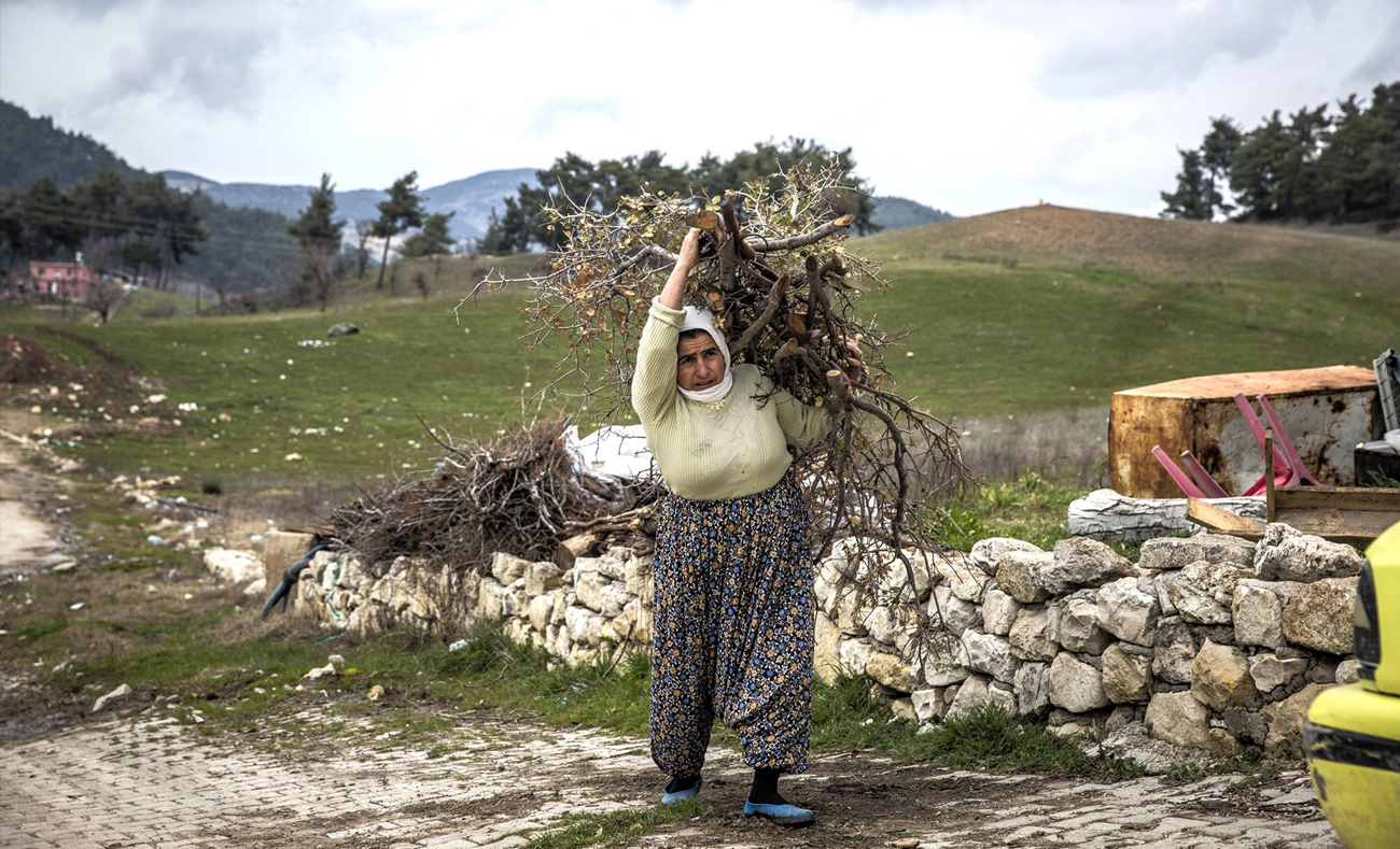 أمرأة تحمل الحطب للتدفئة في مخيم يايلاداغي الحدودي في تركيا، 22 فبراير 2016 - (إيرين)