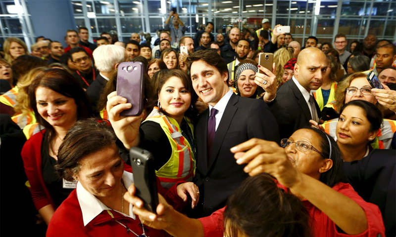 لاجئون سوريون يلتقطون الصور مع رئيس الوزراء الكندي جاستن ترودو - (انترنت)
