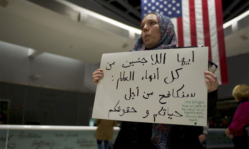 مواطنة أمريكية تتظاهر تعاطفًا مع اللاجئين ضد قرار الرئيس الأمريكي، دونالد ترامب، في مطار فلادلفيا 28 كانون الثاني 2017 (Nur)