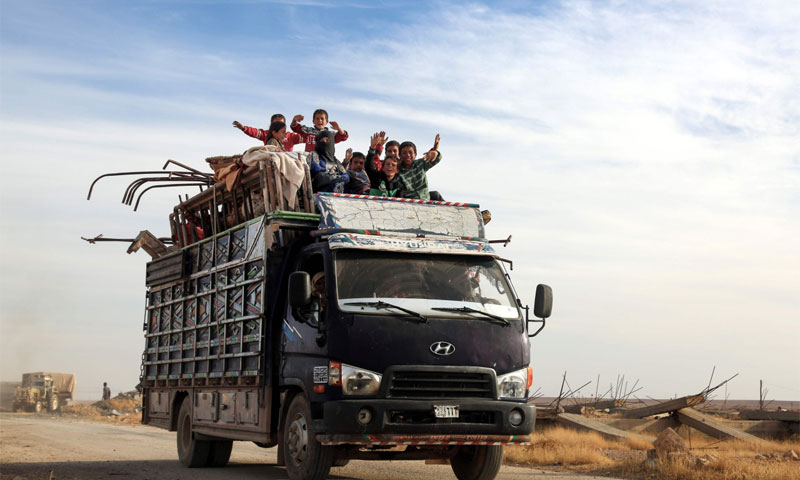 أطفال سوريين يعتلون شاحنة أثناء خروجهم من مدينة الرقة - أيلول 2016 -(AFP)