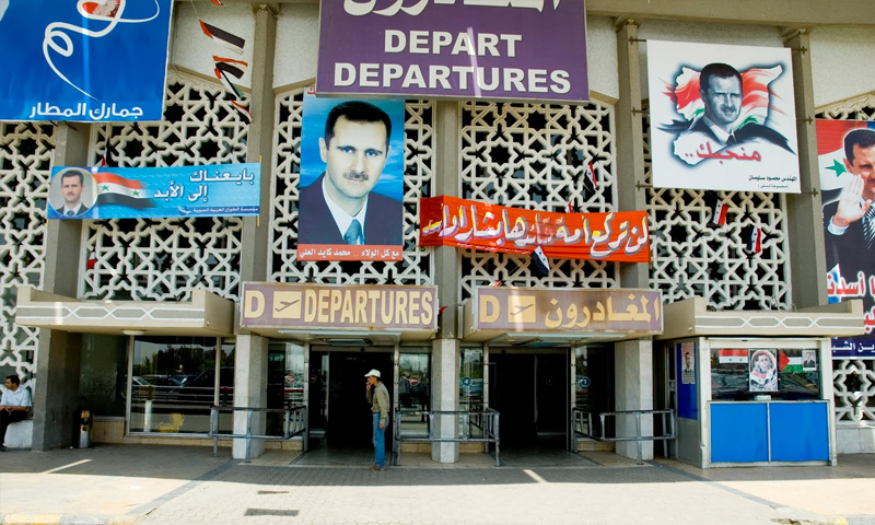 لافتات تدعم رئيس النظام السوري بشار الأسد في مطار دمشق (إنترنت)