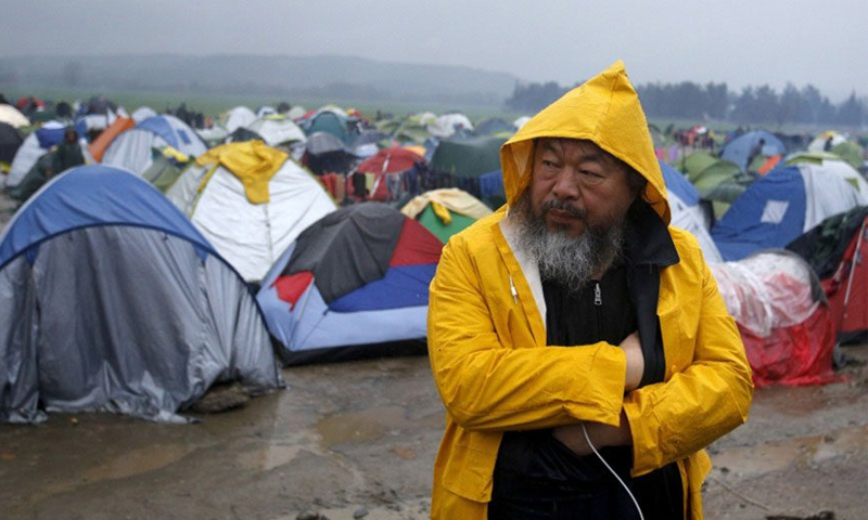 الفنان الصيني آي وي وي خلال زيارته لمخيم "إيدوميني" في اليونان - (انترنت)