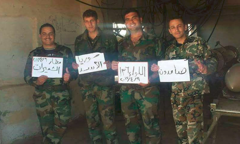 عناصر من قوات الأسد يرفعون لافتات داخل مطار الشعيرات شرق حمص - 9 نيسان 2017 (صفحات موالية للأسد في فيس بوك)
