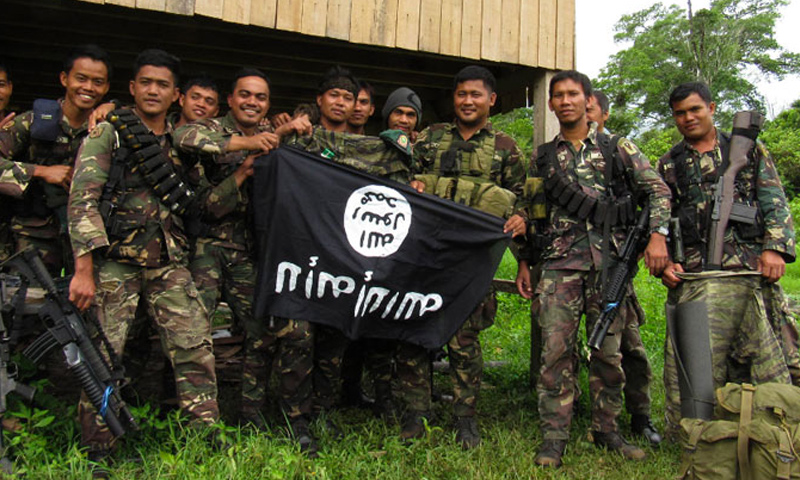 جنود في الفيلبين يحملون راية وجدوها أثناء ملاحقة عناصر من تنظيم "الدولة" (AFP)