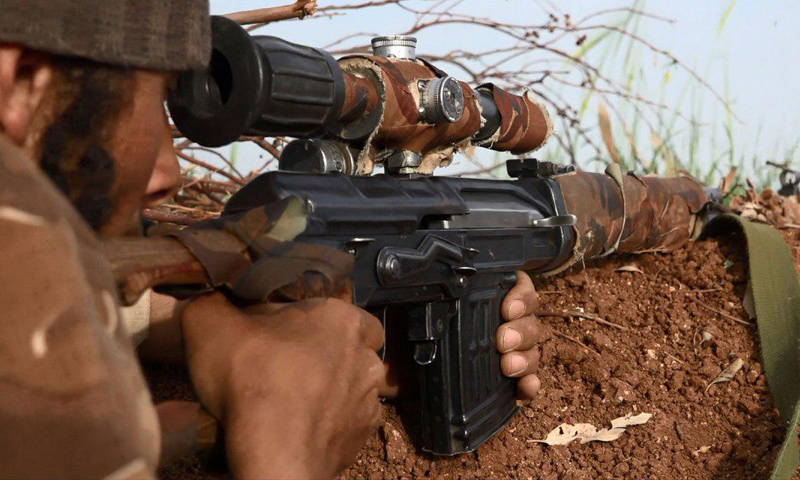 مقاتل من "جيش خالد بن الوليد" على أطراف مساكن جلين في ريف درعا الغربي (تلغرام)