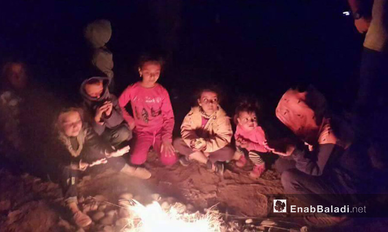 أطفال سوريون يتجمعون حول نار في ليل الصحراء بين المغرب والجزائر - أيار 2017 (عنب بلدي)