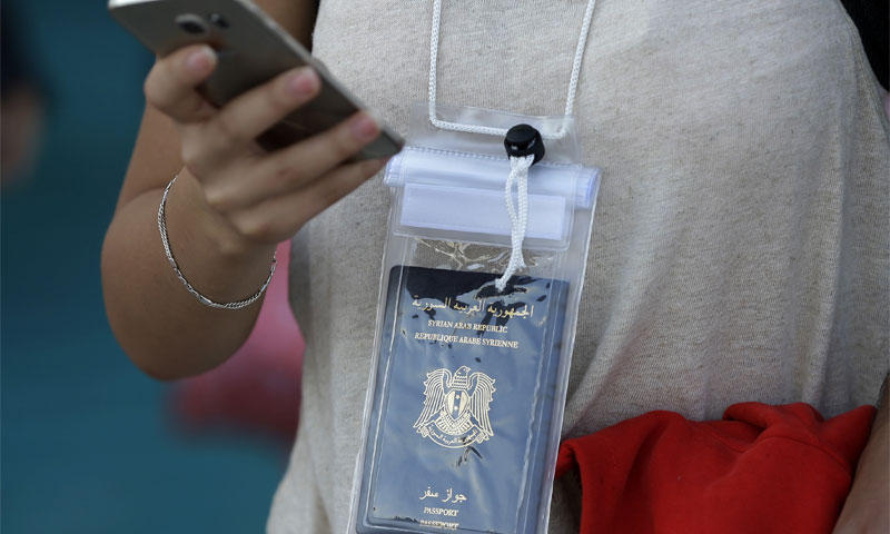لاجئة سورية تحمل جواز سفرها (AP)
