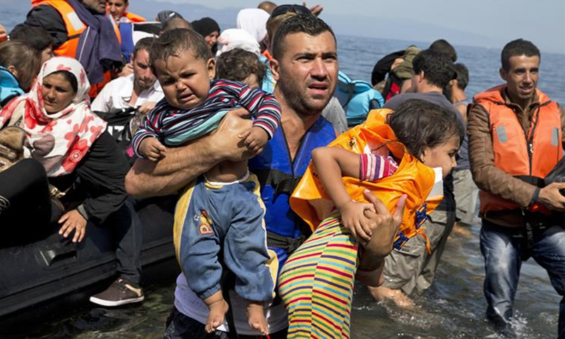 لاجئون سوريون بعد وصولهم من تركيا إلى جزيرة ليسبوس اليونانية - (AP)