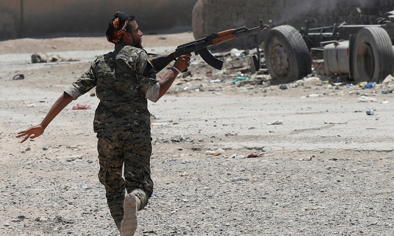 مقاتل من قوات سوريا الديموقراطية خلال المواجهات العسكرية مع تنظيم الدولة في مدينة الرقة - حزيران 2017 - (رويترز)